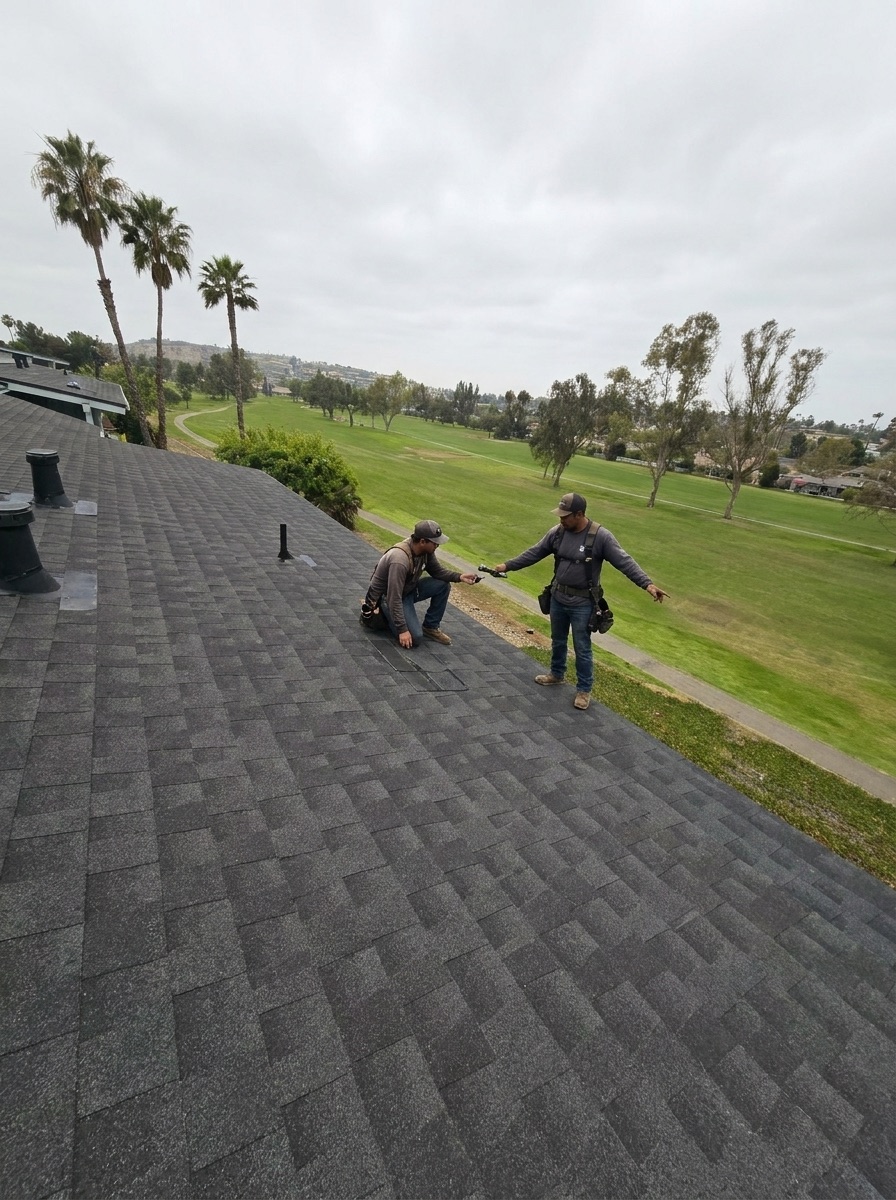 Two roofers inspecting a shingle roof
