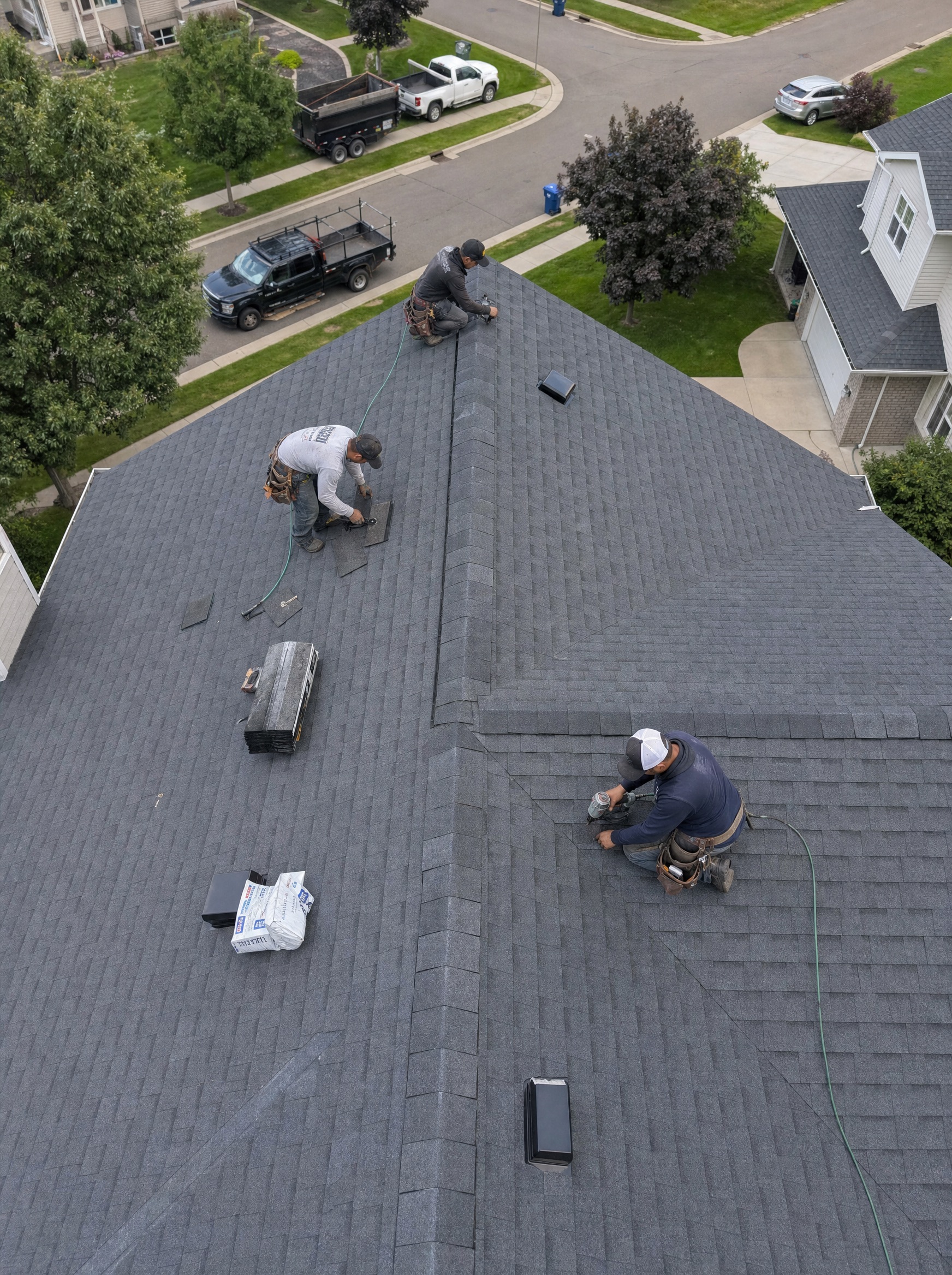 Aerial view of a roofing crew working across a full residential roof